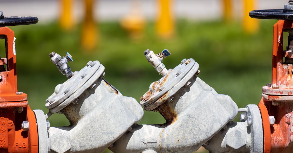 Detailed view of rusted industrial gas valves outdoors on a sunny day.