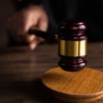 A gavel striking a sound block, symbolizing justice and legal authority in a courtroom setting.