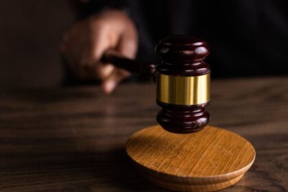 A gavel striking a sound block, symbolizing justice and legal authority in a courtroom setting.