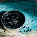 A compass resting on a map of China and India signifies exploration and adventure.